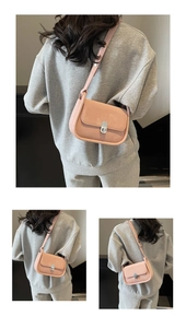 Detail view of the pink suede shoulder bag featuring a silver metal twist lock closure