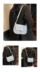 Detail view of a light blue commuter square bag with silver twist lock and matte texture