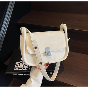 Detail of off-white square crossbody bag with silver textured metal clasp and rivets
