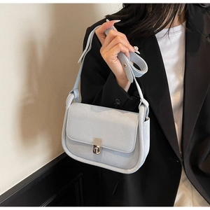 Detailed view of light blue shoulder bag featuring a polished silver press-lock closure