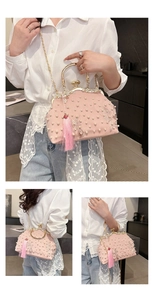 Detailed view of pink embroidered evening clutch with pearls, crystals and long tassels