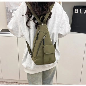 Close-up of olive green tactical chest bag featuring buckle pocket and rabbit logo detail