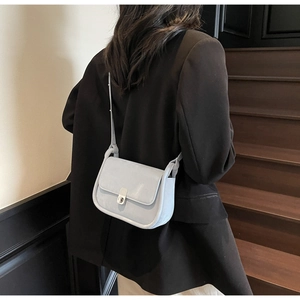 Detail showing elegant silver metal twist lock and light blue textured leather handbag