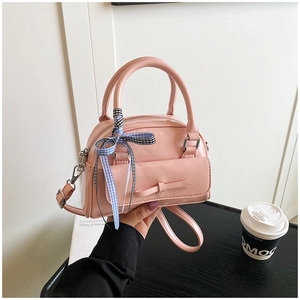 Détail du sac bowling en cuir PU rose avec poche à nœud et ruban de soie élégant