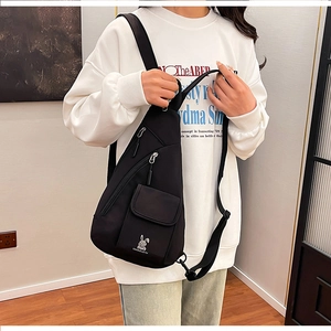Detail of black nylon chest bag showing multi-zipper pockets and cute rabbit logo design
