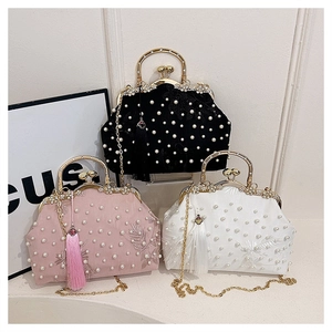 Detailed embroidery and pearl embellishments on vintage silk evening bags with tassels