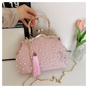 Detail of pink satin evening bag with floral pearl embroidery and gold hollow handle