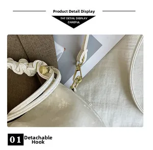 Close-up of detachable gold metal hook and white embossed scale texture leather bag