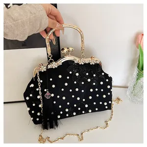 Detail of black satin evening bag featuring pearl embroidery and floral lace accents