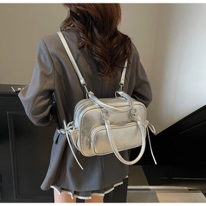 Macro detail of silver metallic Boston bag showing backpack straps and smooth faux leather