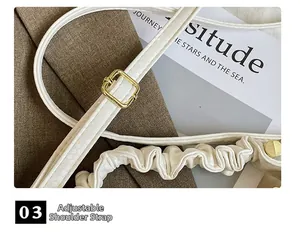Detailed view of the adjustable white shoulder strap with elegant gold buckle and ruffles