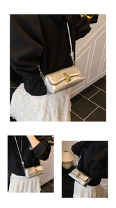 Detail of silver metallic shoulder bag featuring a gold twist lock and knotted strap design