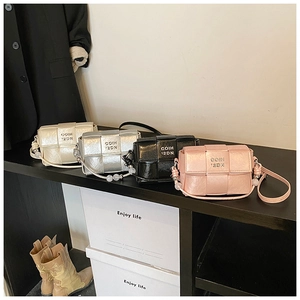 Detail of woven crossbody bags in cream, silver, black, and pink with bead straps