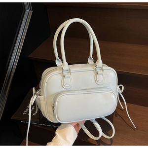 Detail of light blue patent leather Boston bag with bow drawstring on wooden stairs