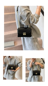Detail of a black faux leather bag with gold chain strap and push-lock closure
