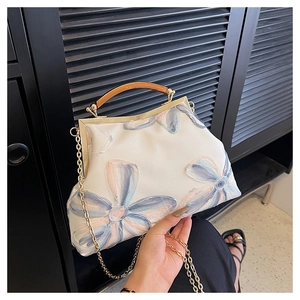 Close-up of vintage kiss-lock bag with floral embroidery and amber resin handle