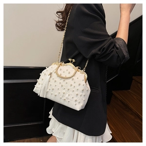 Close-up of white satin evening bag featuring pearl beads, embroidery and silk tassels