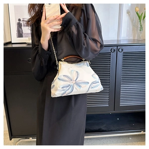 Detailed blue floral embroidery on white retro crossbody bag with tortoise handle