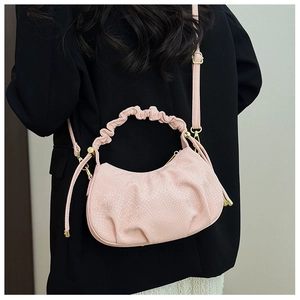 Detail of light pink fish scale texture bag with elegant pleated handle and gold hardware