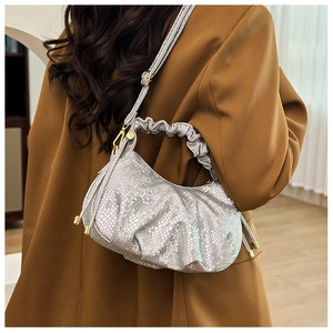 Fashionable silver pleated handbag with fish scale texture and tassel detail on model