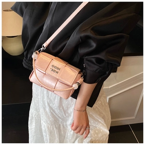 Detailed close-up of pink woven crossbody bag with silver logo and long strap