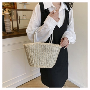 Détail du sac cabas en paille tissée beige avec anses argentées pour le style de plage