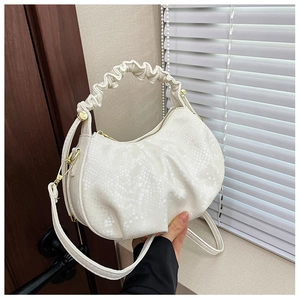 Detail of white pleated cloud bag showing fish scale texture and gold metal hardware
