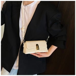 Detail of cream glossy leather shoulder bag with gold metal buckle and knotted strap
