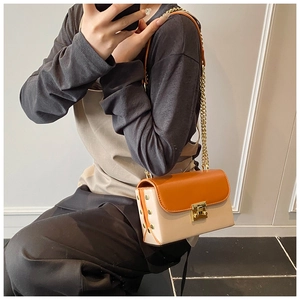 Detail of color-block flap bag with gold chain strap, square lock and side rivet accents