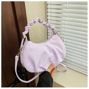 Close-up of lavender pleated handbag with snake texture and gold hardware details