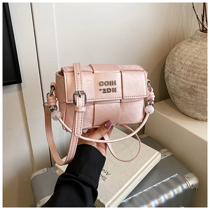Close-up of pink woven crossbody bag featuring silver metal logo and bead strap detail
