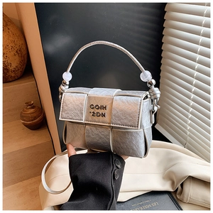 Detail of silver metallic woven handbag featuring pearl handles and COIH 2DN logo