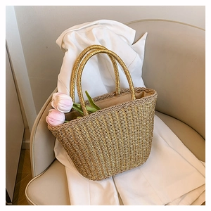 Dettaglio della borsa tote in paglia intrecciata con manici tondi e decoro di tulipani
