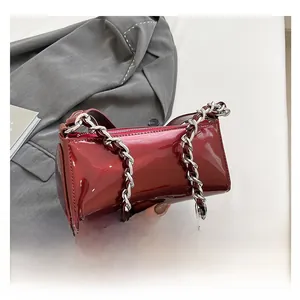 Close-up of dark red patent leather cylinder bag with silver chunky chain handle