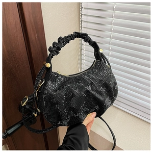 Detail showing black fish-scale texture leather hobo bag with gold sphere hardware accents
