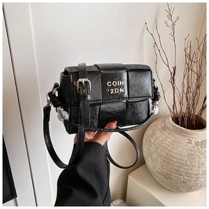 Detail of black woven crossbody bag with metallic logo and decorative beaded handle
