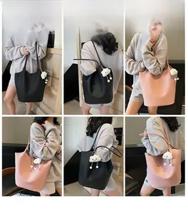 Detail view of large lychee pattern bucket bag featuring a cloud plush pendant charm