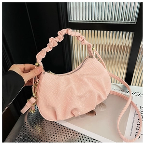 Detail of pink fish scale textured handbag with trendy cloud ruched handle and gold hardware