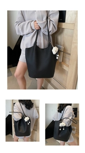 Detail of black pebble leather tote bag featuring a cute white cloud plush charm