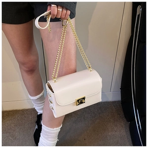 Detail of cream white leather bag with gold chain strap and metallic buckle