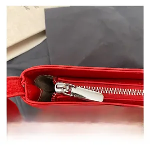 Dettaglio borsa rossa in pelle a grana con cerniera in metallo argentato elegante