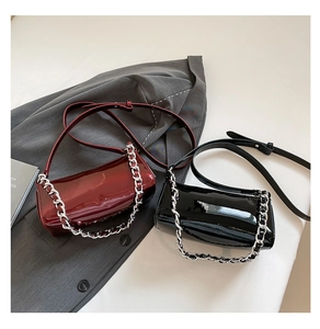 Detail of burgundy and black patent leather baguette bags with silver chain straps
