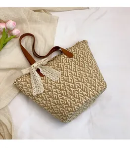Detail of hand-woven straw bag with leather handle, lace bow, and tulip decoration