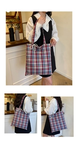 Detail of red and blue plaid tote bag featuring a decorative pearl bow charm accessory