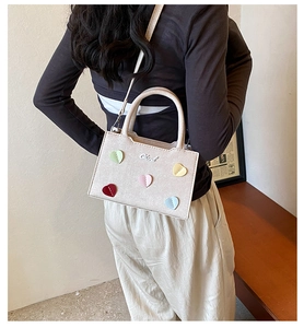 Détail du sac à main en cuir crème avec cœurs colorés et bandoulière réglable pour femmes