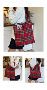 Detailed shot of red and green plaid tote bag with lace bow and pearl accents
