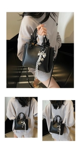 Detail of lychee pattern leather bucket bag with silver heart charm and woven strap