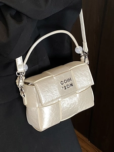 Pearlescent beige woven crossbody bag with silver logo detail shown on shoulder