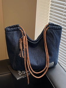 Deep blue denim tote bag with brown woven rope handles and a tassel knot pendant decoration