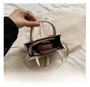 Vue intérieure du mini sac beige montrant la poche zippée et la capacité de rangement
